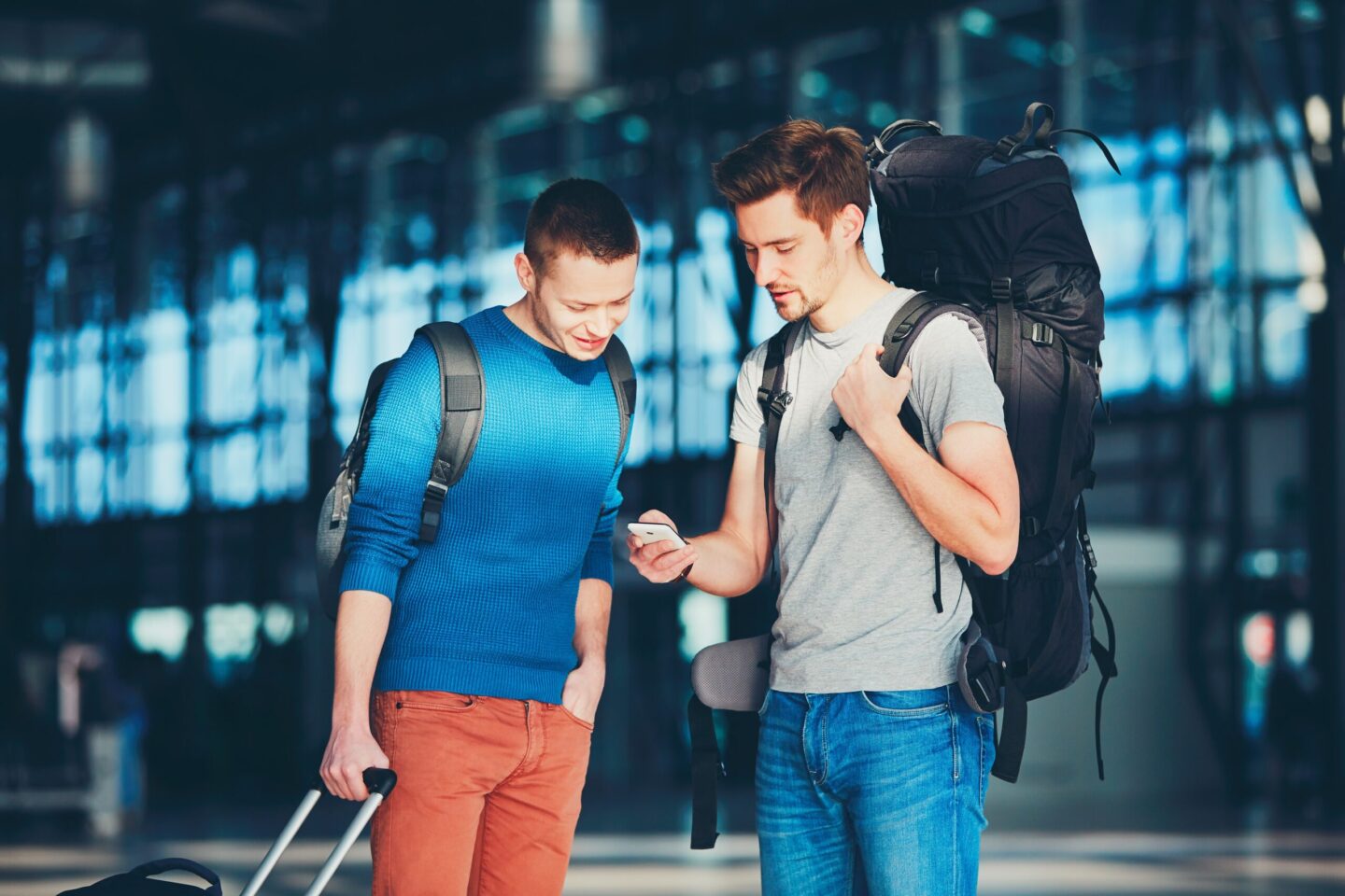Two friends utilizing a digital mapping platform at the airport.